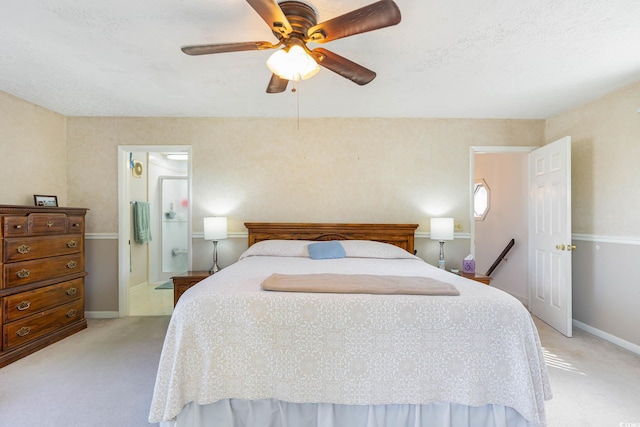 bedroom with light colored carpet, baseboards, ceiling fan, and ensuite bathroom