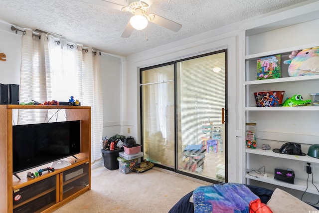 sitting room featuring carpet, a textured ceiling, and a ceiling fan