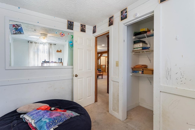 bedroom featuring carpet floors, a textured ceiling, and a closet