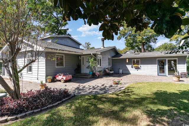 rear view of house featuring a lawn and a patio area