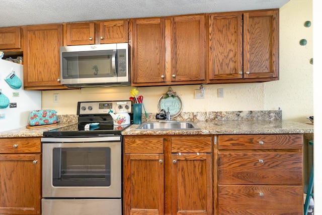 kitchen featuring sink, appliances with stainless steel finishes, and a textured ceiling