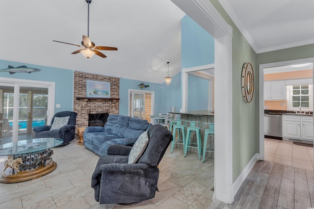 living room with a wealth of natural light, ornamental molding, a fireplace, and ceiling fan