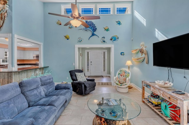 living room with ceiling fan, high vaulted ceiling, and light tile patterned floors