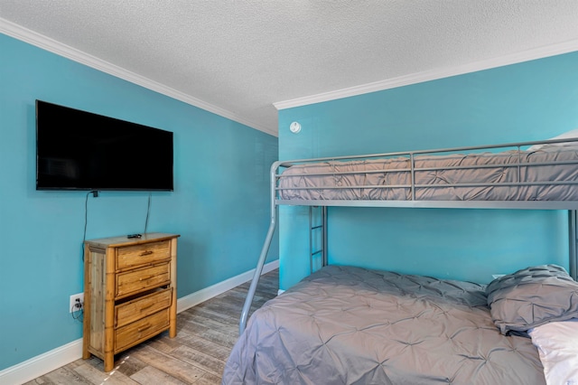 bedroom featuring ornamental molding, a textured ceiling, and hardwood / wood-style flooring