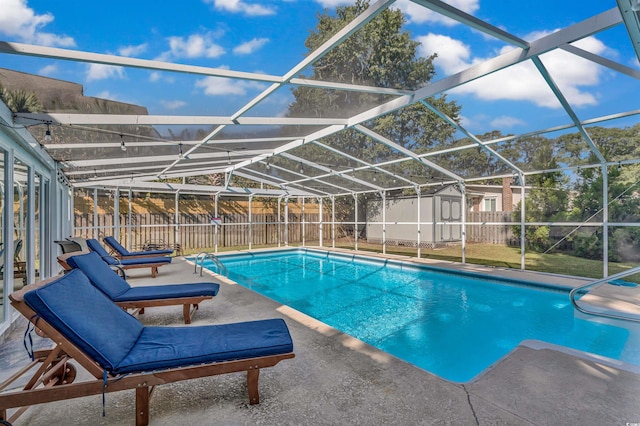 view of swimming pool with a shed, a patio area, and a lanai