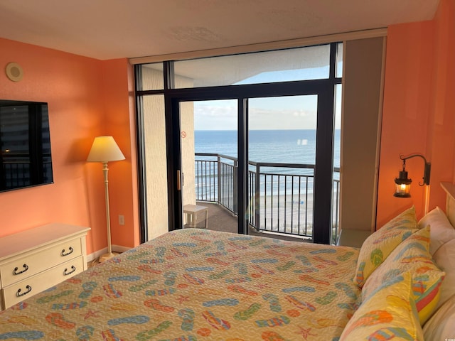 bedroom with multiple windows, access to exterior, and a water view