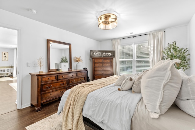 bedroom with dark hardwood / wood-style flooring