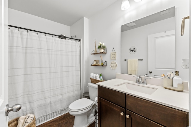 bathroom with vanity, toilet, and hardwood / wood-style floors