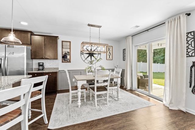 dining area with a notable chandelier and dark hardwood / wood-style floors