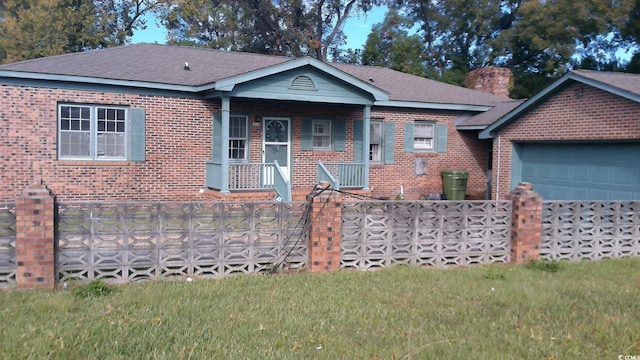 view of front of home with brick siding, a front lawn, a chimney, and a porch
