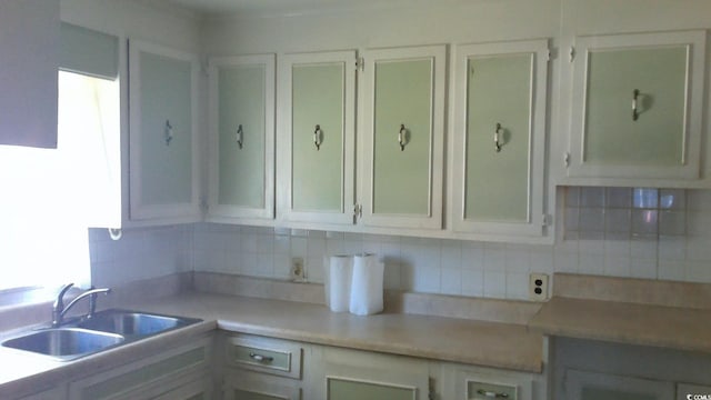 kitchen featuring decorative backsplash, white cabinetry, and sink