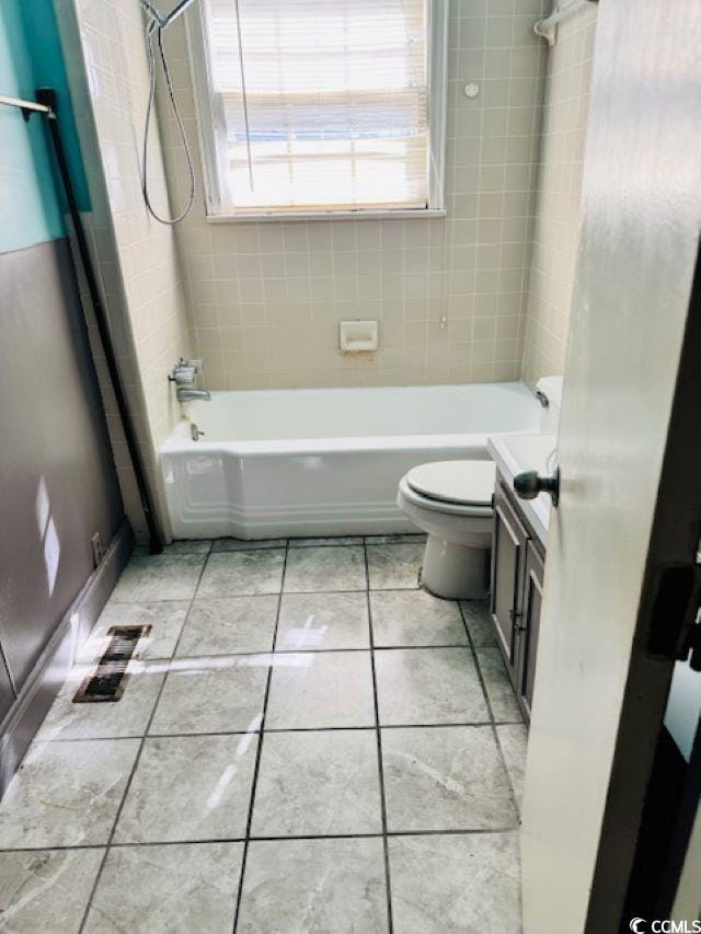 full bathroom featuring vanity, toilet, tile patterned floors, and tiled shower / bath