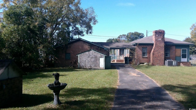 ranch-style home with central air condition unit and a front yard