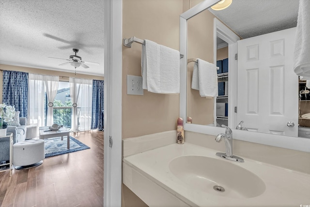 bathroom with ceiling fan, hardwood / wood-style flooring, a textured ceiling, and sink