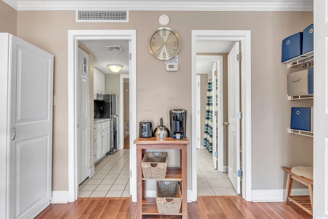 hall featuring light hardwood / wood-style floors and crown molding