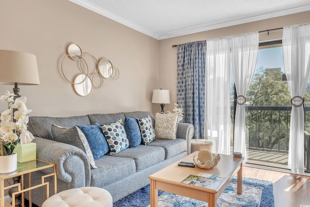 living room with a textured ceiling, crown molding, and wood-type flooring