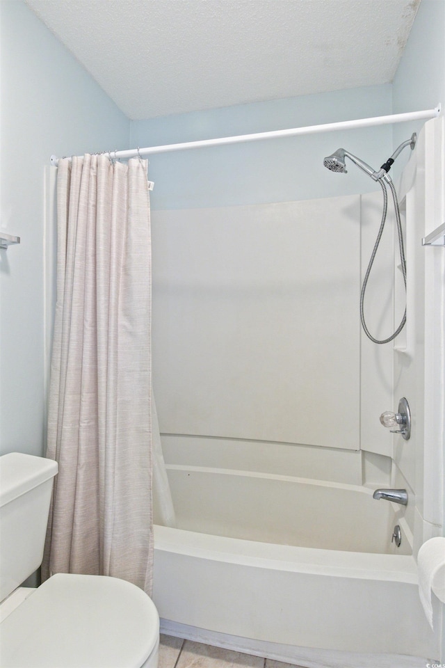 bathroom featuring toilet, tile patterned floors, shower / bath combo with shower curtain, and a textured ceiling