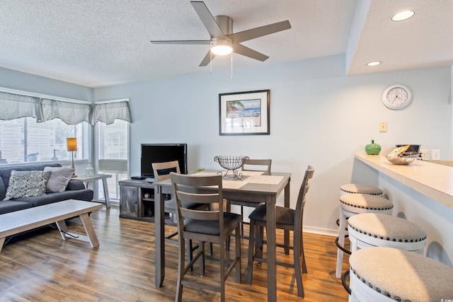 dining space with hardwood / wood-style floors, a textured ceiling, and ceiling fan