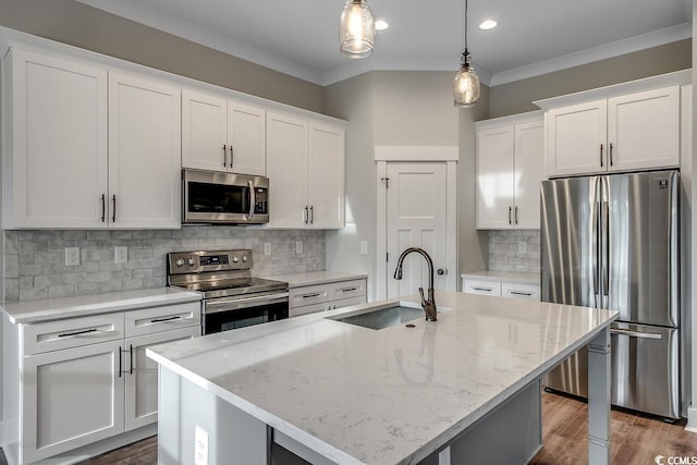 kitchen with decorative backsplash, stainless steel appliances, a kitchen island with sink, sink, and pendant lighting