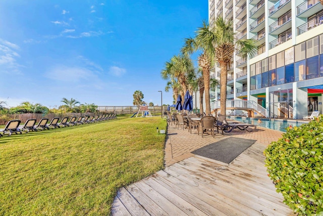 exterior space featuring a balcony, a community pool, and a lawn