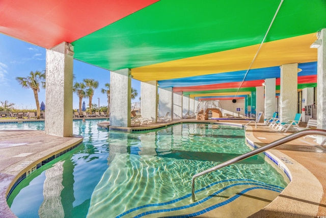 view of swimming pool with a water view, a hot tub, and a patio area