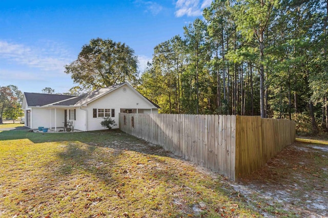 view of side of home with a patio and a lawn