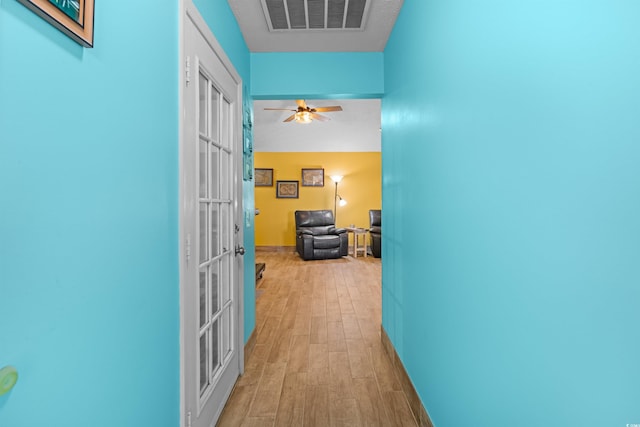 hall featuring light hardwood / wood-style flooring and french doors