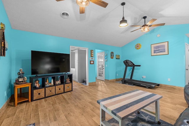 exercise area with lofted ceiling, light hardwood / wood-style flooring, and ceiling fan