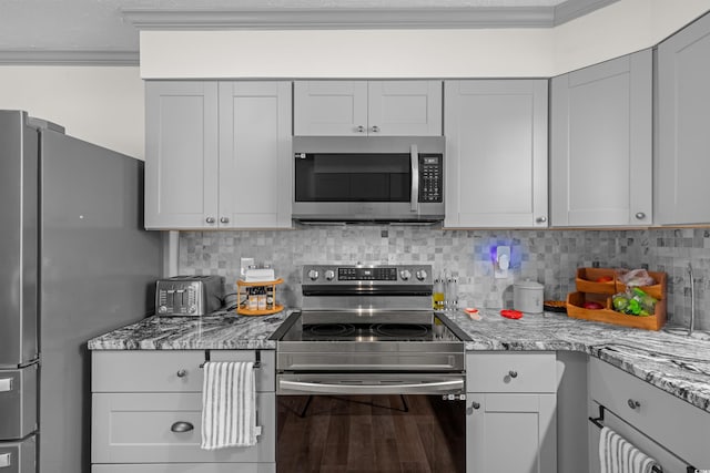 kitchen featuring crown molding, hardwood / wood-style flooring, appliances with stainless steel finishes, and backsplash