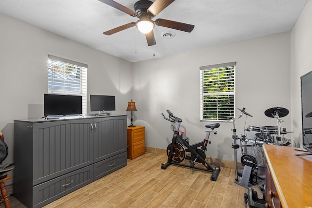 exercise room featuring ceiling fan, a wealth of natural light, and light wood-type flooring