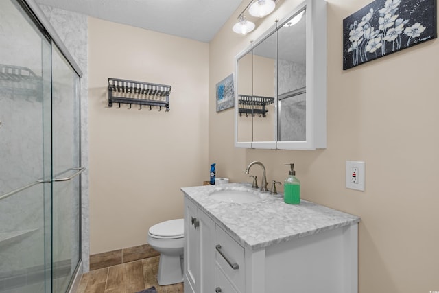 bathroom featuring vanity, an enclosed shower, hardwood / wood-style floors, and toilet