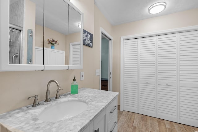 bathroom featuring vanity, hardwood / wood-style floors, and a shower with door