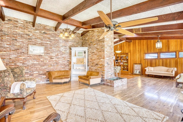 living area with vaulted ceiling with beams, hardwood / wood-style flooring, wooden walls, brick wall, and ceiling fan