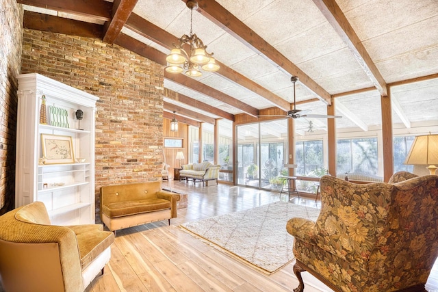 living room with a healthy amount of sunlight, brick wall, light wood-type flooring, and lofted ceiling with beams