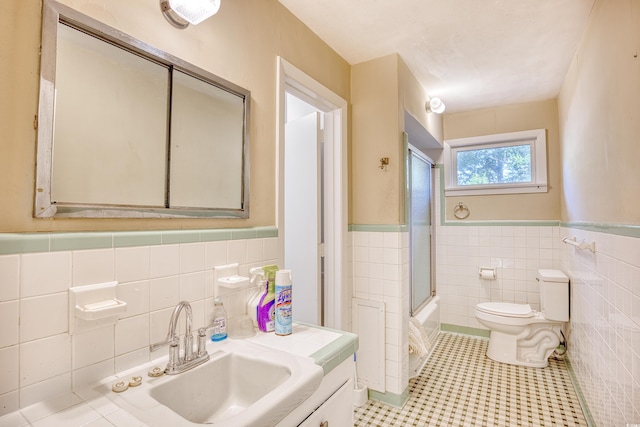 full bathroom featuring tile walls, vanity, toilet, and tile patterned flooring