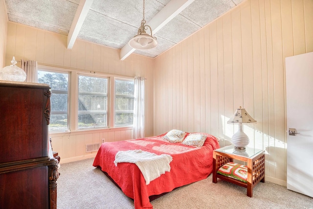 bedroom featuring beamed ceiling, carpet floors, and wooden walls