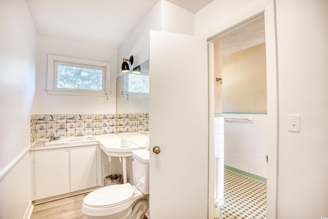 bathroom featuring toilet, hardwood / wood-style floors, vanity, and tile walls