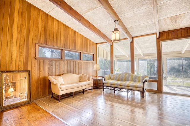 interior space featuring vaulted ceiling with beams, wood walls, hardwood / wood-style floors, and a wealth of natural light