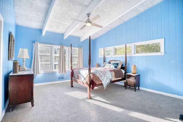 bedroom with vaulted ceiling with beams, wooden walls, carpet flooring, and ceiling fan