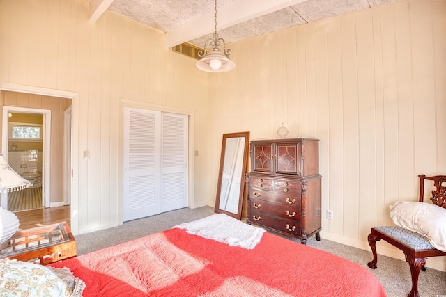 carpeted bedroom with ceiling fan, beamed ceiling, and wooden walls