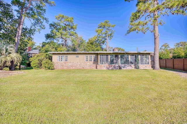 rear view of property with a yard and a sunroom