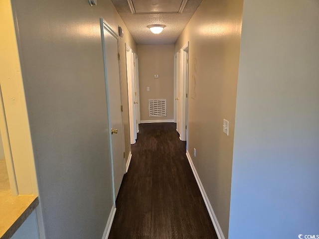 corridor featuring dark hardwood / wood-style flooring and a textured ceiling