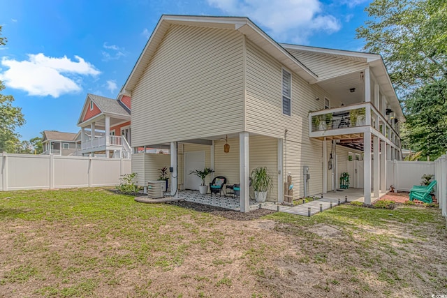 back of house with a patio area and a yard