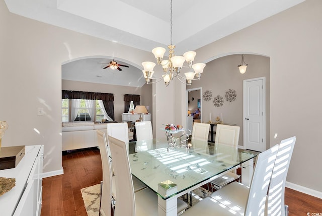 dining room with ceiling fan with notable chandelier and dark hardwood / wood-style floors