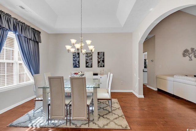 dining space with dark wood-type flooring and a notable chandelier