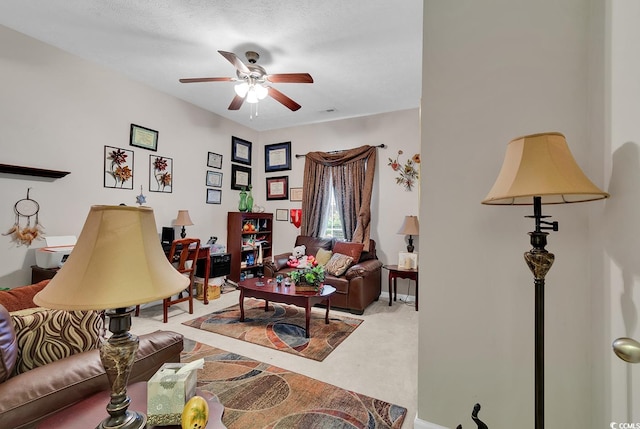 living room featuring ceiling fan, carpet, and a textured ceiling