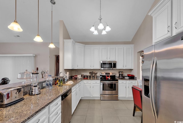 kitchen featuring stainless steel appliances, vaulted ceiling, pendant lighting, white cabinets, and dark stone countertops