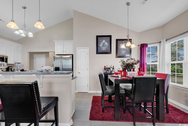 tiled dining space with high vaulted ceiling and a notable chandelier