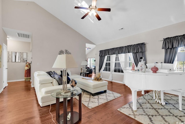 living room with ceiling fan, high vaulted ceiling, wood-type flooring, and a wealth of natural light