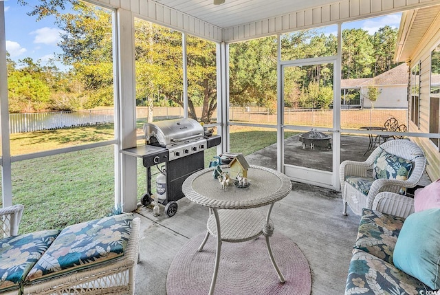 sunroom featuring a water view and wooden ceiling